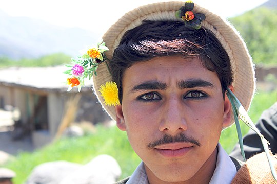 "Young_Pashai_man_with_flowers_in_his_hair.jpg" by User:Geo Swan
